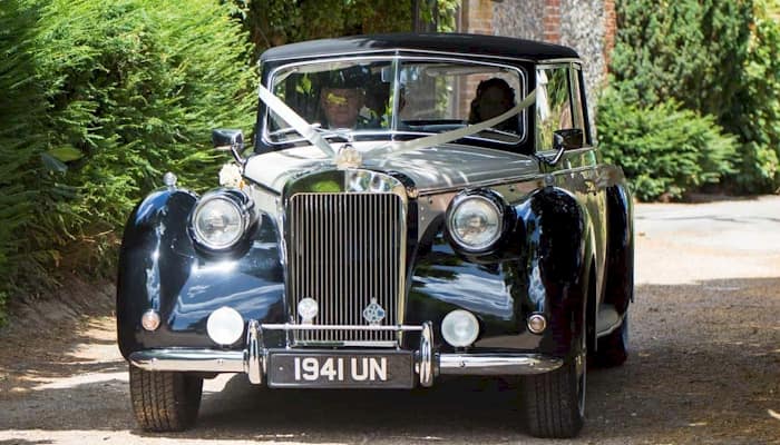 Front view of the Royale Windsor wedding car with driver and the Bride and Groom inside