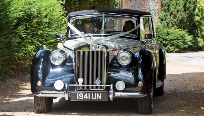 Front view of the Royale Windsor wedding car with driver and the Bride and Groom inside